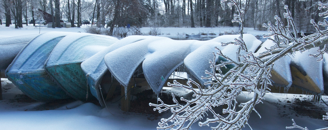 Snow and ice covered canoes.